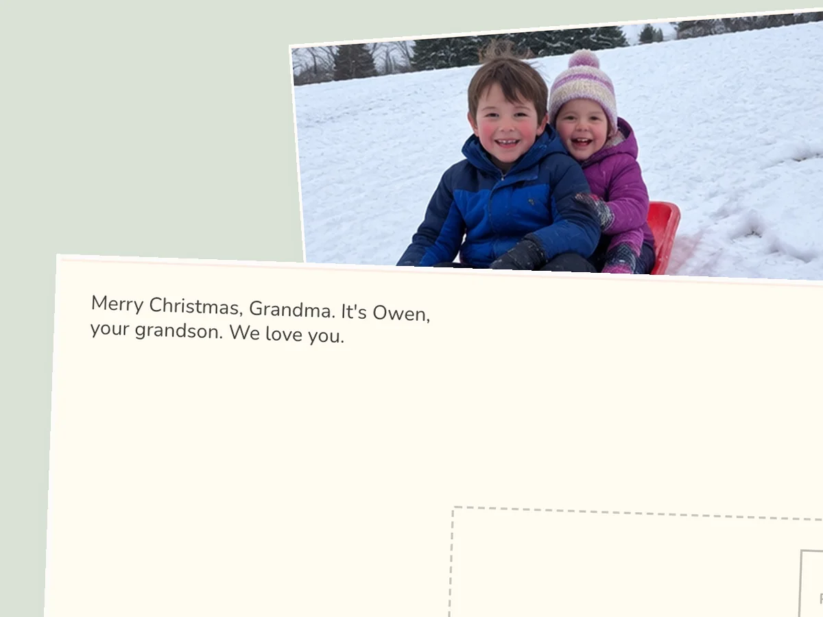 Plain postcard back in clear print type: Merry Christmas, Grandma, it's Owen, your grandson, with two children's faces on a sled on the front