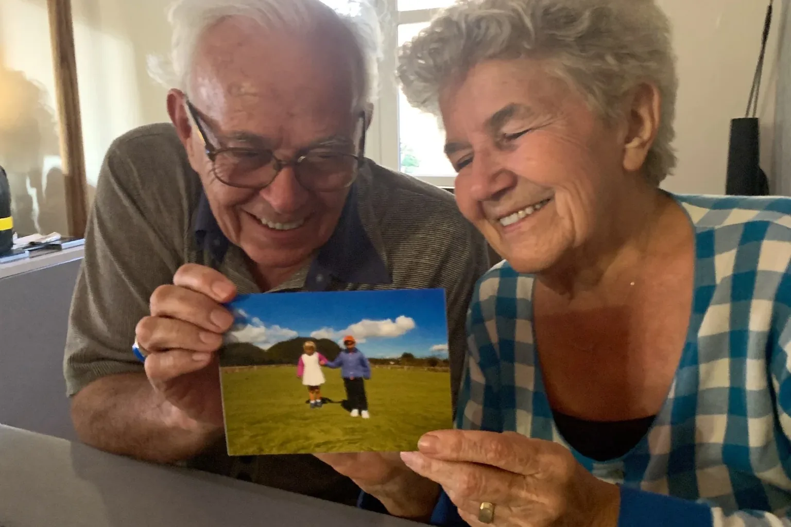Gifts for grandpa: a grandfather holding a printed 4×6 photo of his grandchildren