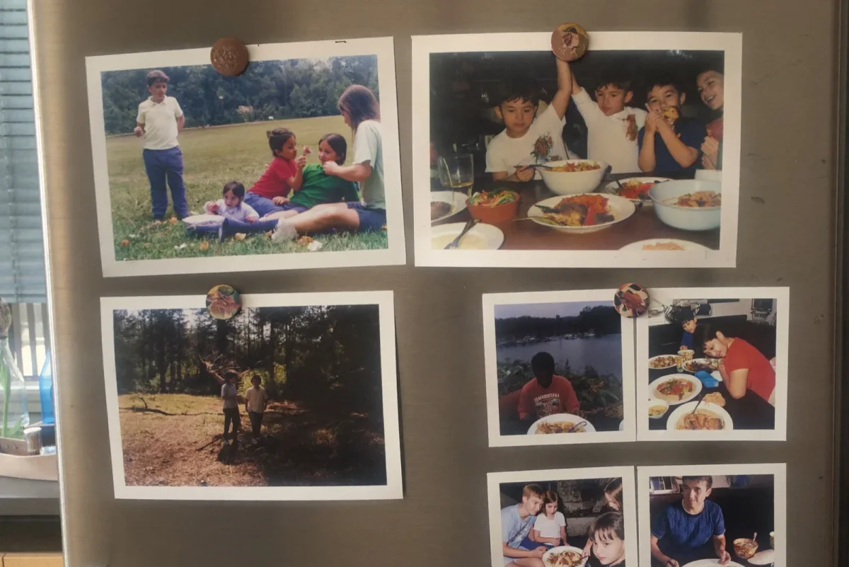 Printed 4×6 family photo postcards held on a fridge door with magnets