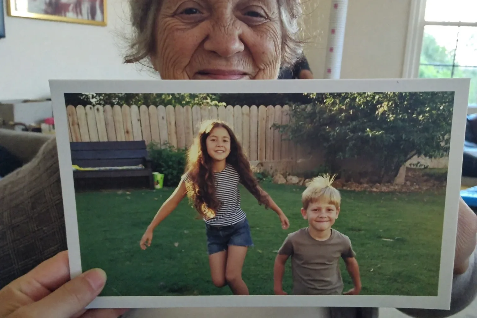 Heartfelt messages for Mother's Day: a mother holding a printed 4×6 photo card of her grandchildren