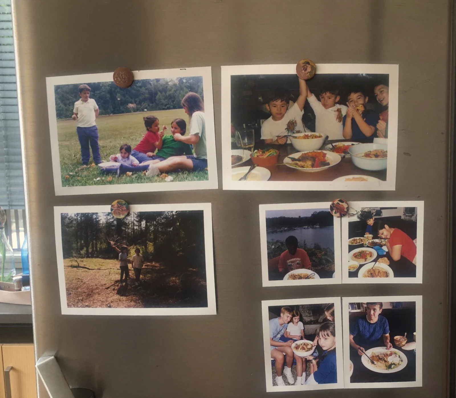 A growing collection of colorful family photo cards displayed on a refrigerator