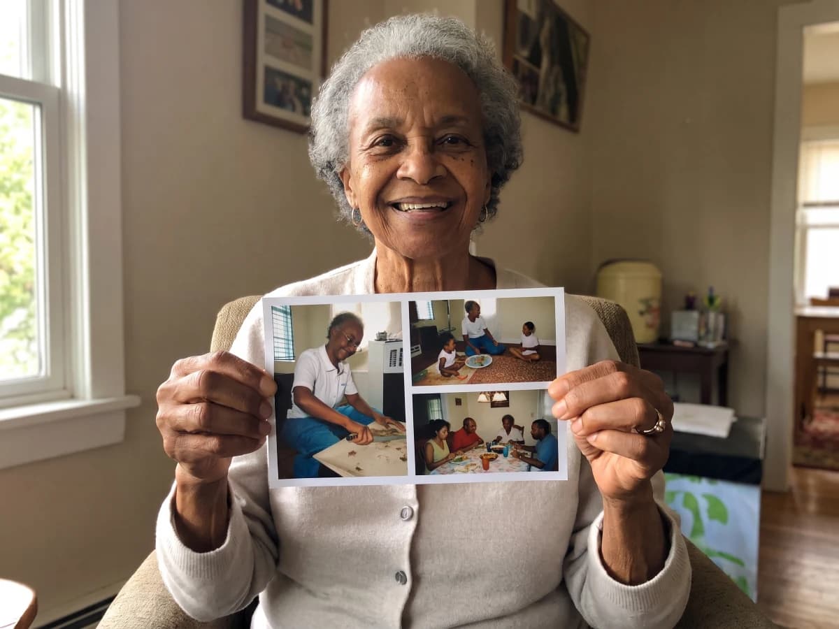 A joyful grandmother holding a postcard with photos of her grandchildren