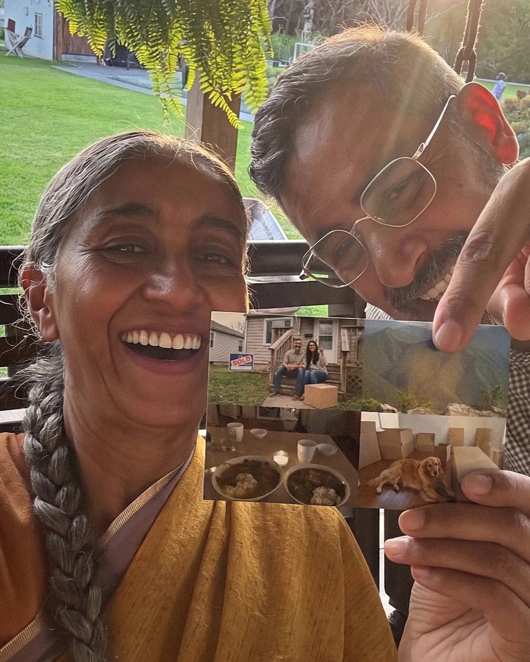 A laughing grandmother and grandfather holding up a photo postcard