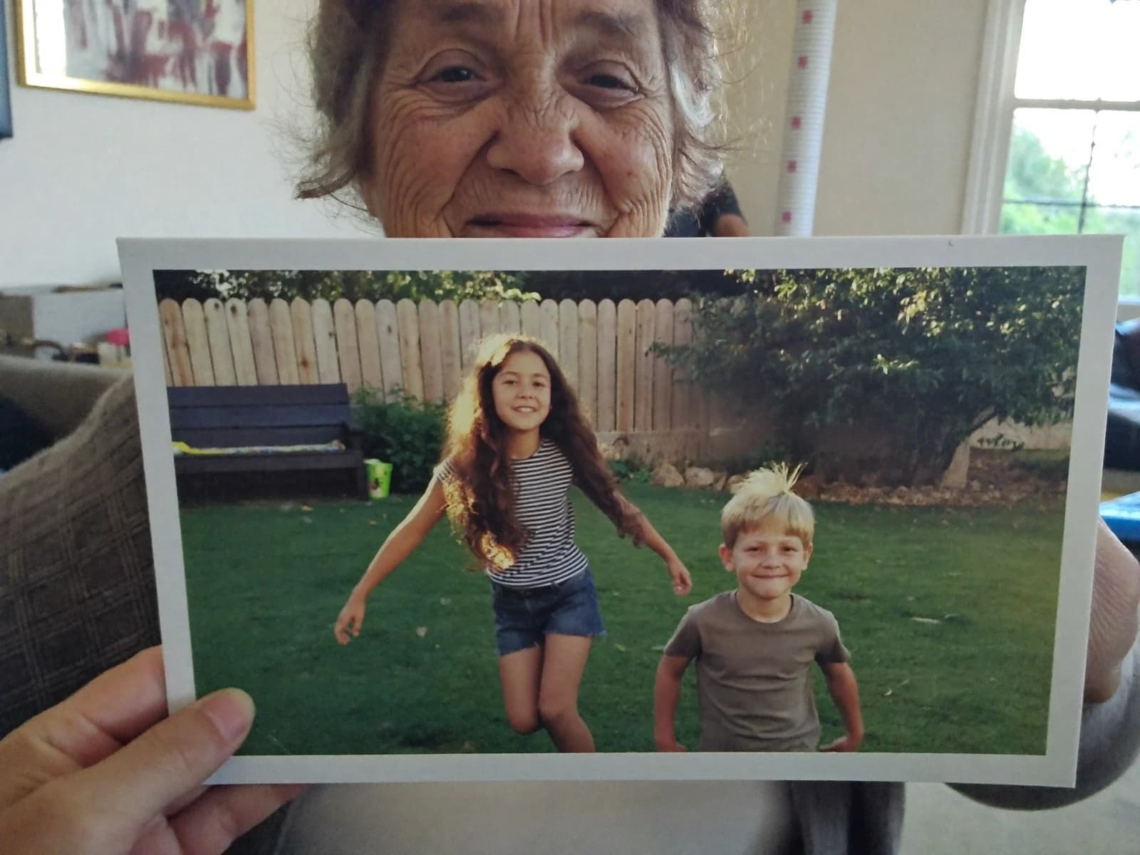 A grandmother in her kitchen holding a FamilyLetter postcard and reading it