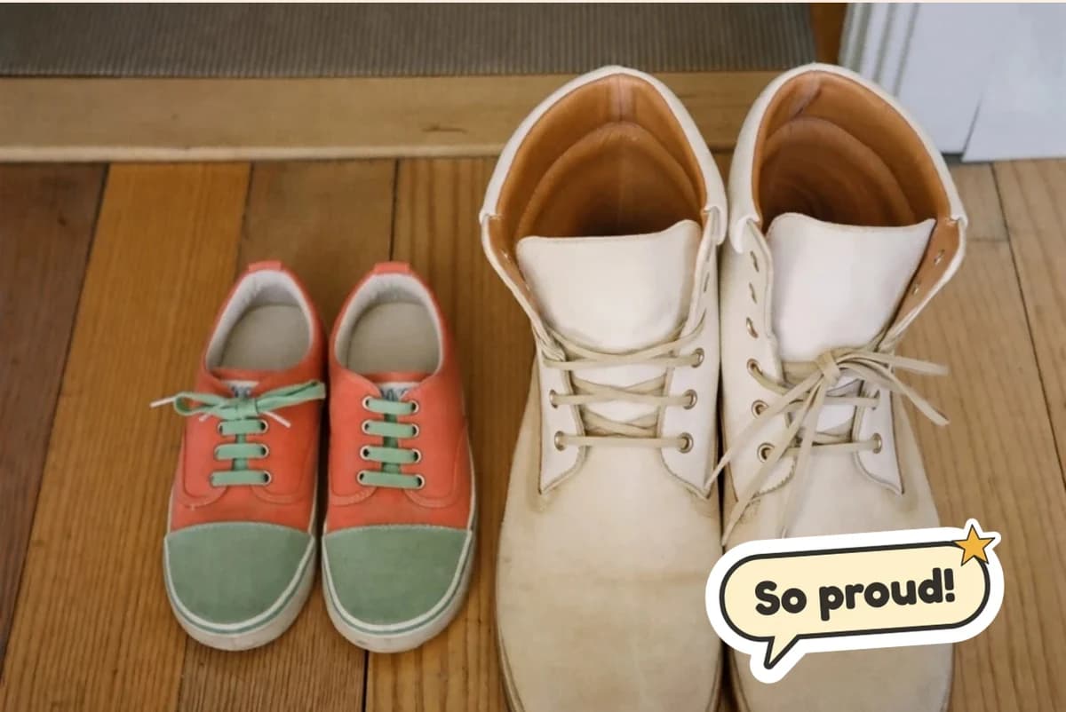 Card front with one photo of a child's coral sneakers beside a pair of worn white boots on a wooden porch, with a So proud! sticker