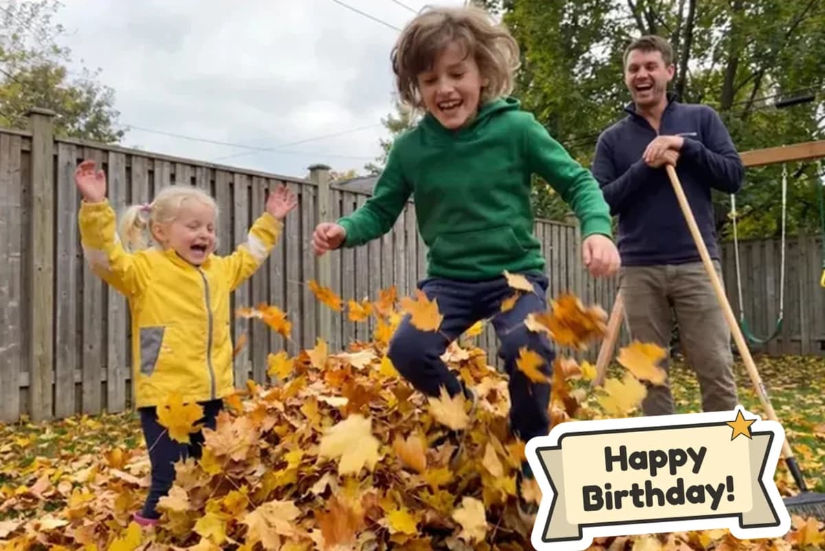 Card front with one photo of a boy jumping into a pile of autumn leaves while his little sister cheers and their dad leans on a rake, with a Happy Birthday sticker